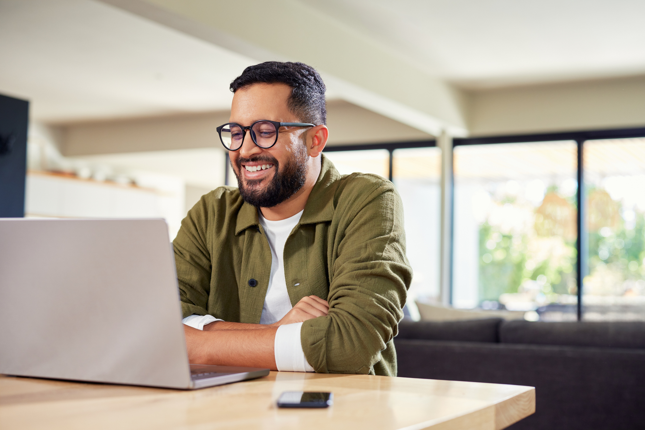 Happy hispanic man working on laptop at home Happy hispanic man working on laptop at home