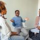 A diverse group of clients meets with a counselor for a therapy session