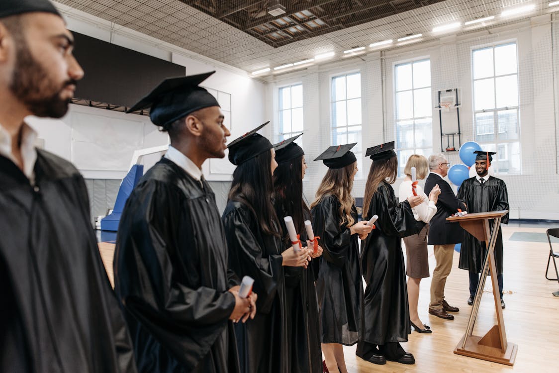 A diverse group of graduates celebrates a doctoral graduation ceremony