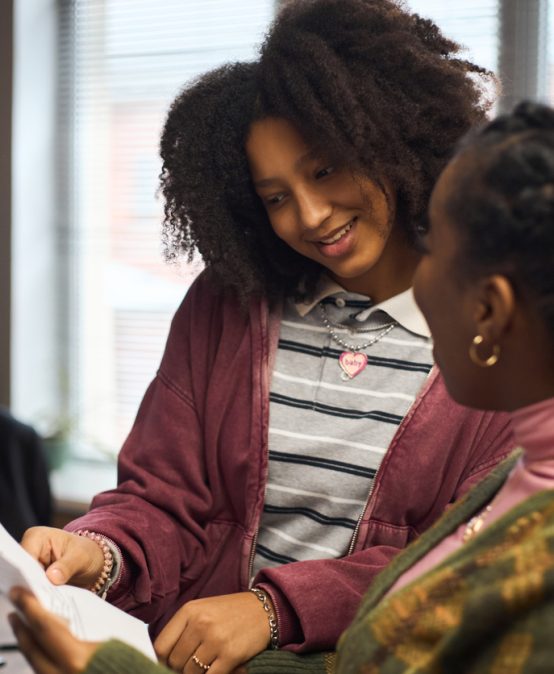 Young Black Woman School Principal Discussing Documents with Colleague in Office