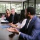 A diverse group of school administrators in professional attire discussing around a conference table