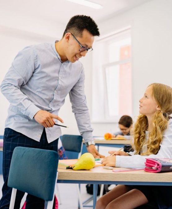 Teacher interacting with diverse students in classroom