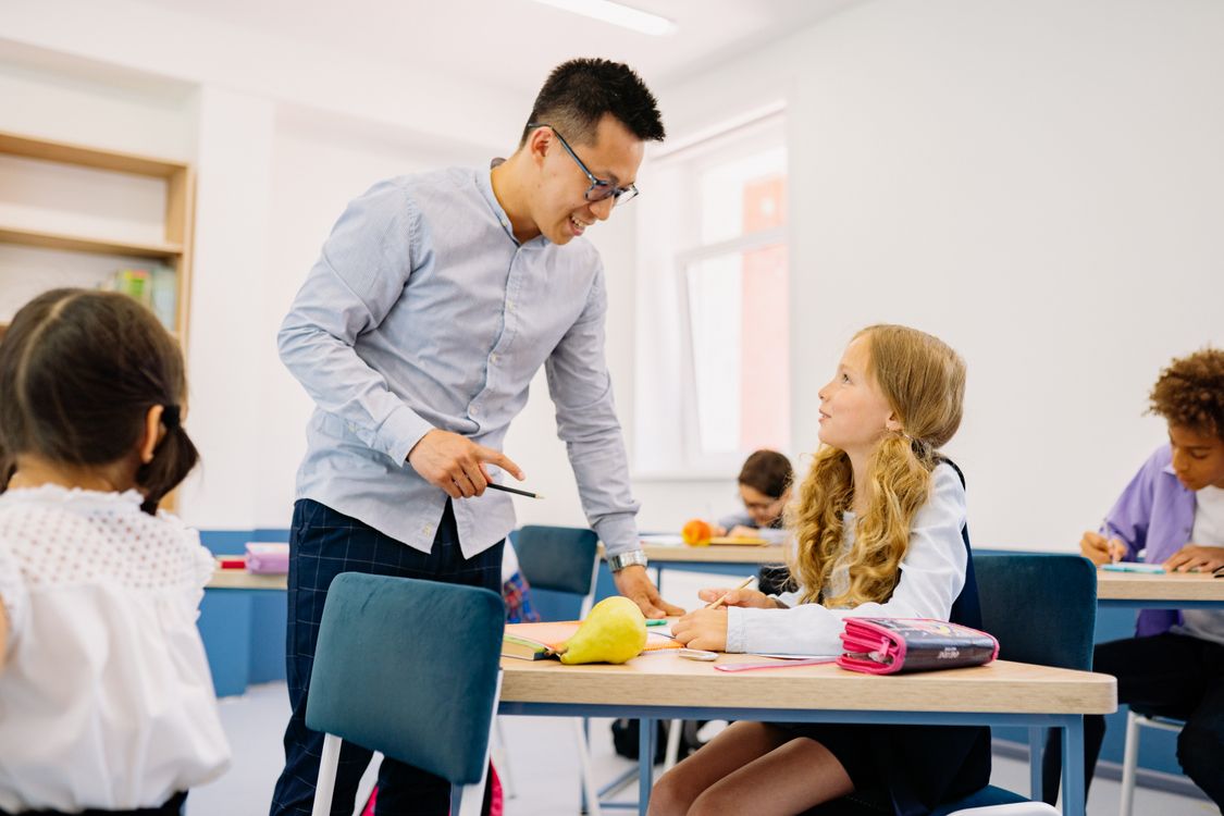 Teacher interacting with diverse students in classroom
