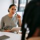 A counselor with a notepad listening attentively to a client during a counseling session
